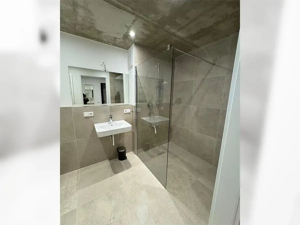 Modern bathroom with underfloor heating, towel dryer and floor-level shower.