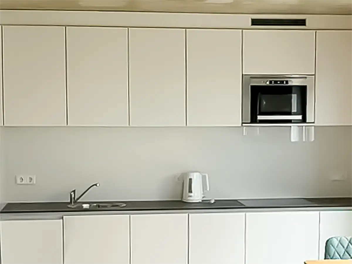 Kitchen area with ceramic hob and microwave oven.